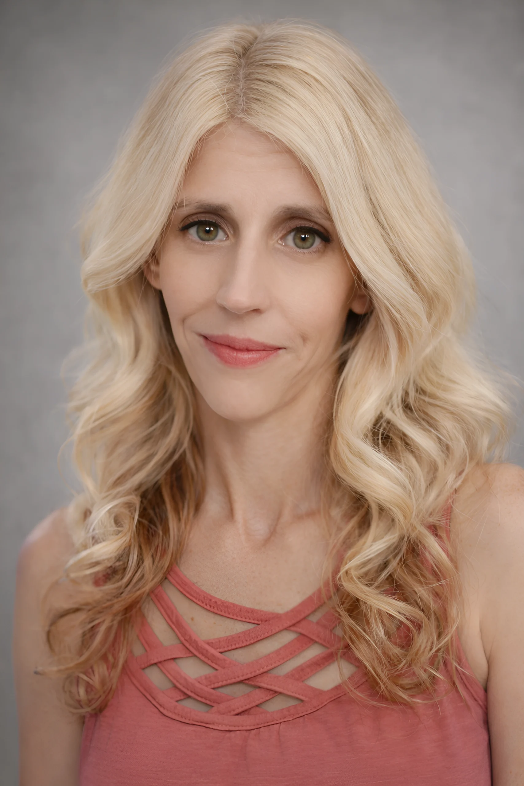 Home 3 Tanya Allison, founder and lead consultant at Talk to Tanya Consulting.A woman with long, wavy blonde hair and hazel eyes wearing a dusty rose-colored top with a crisscross strap neckline against a neutral gray background.